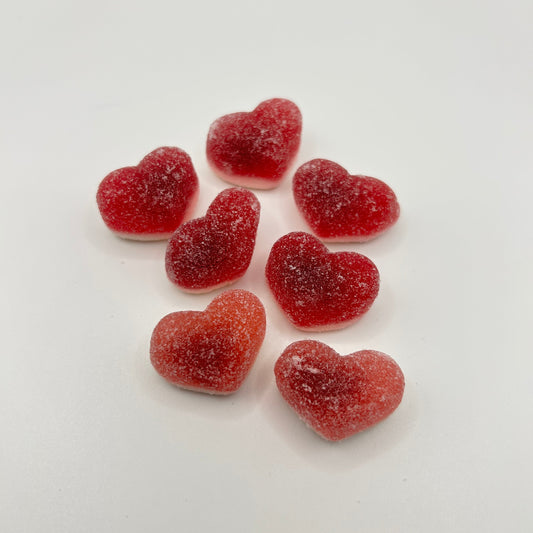 Heart-shaped red gummy candies on a white background